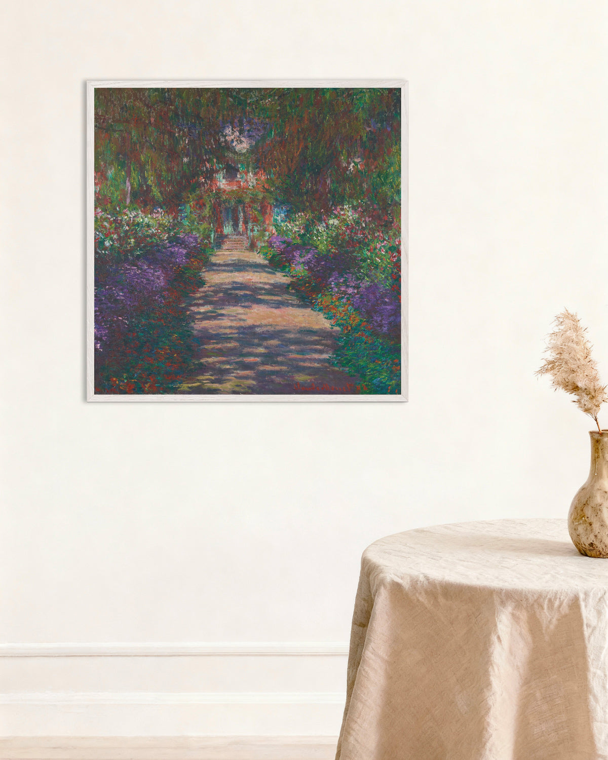 Claude Monet’n Kuja Monet’n puutarhassa Givernyssä (1902) -juliste valkoisessa puukehyksessä