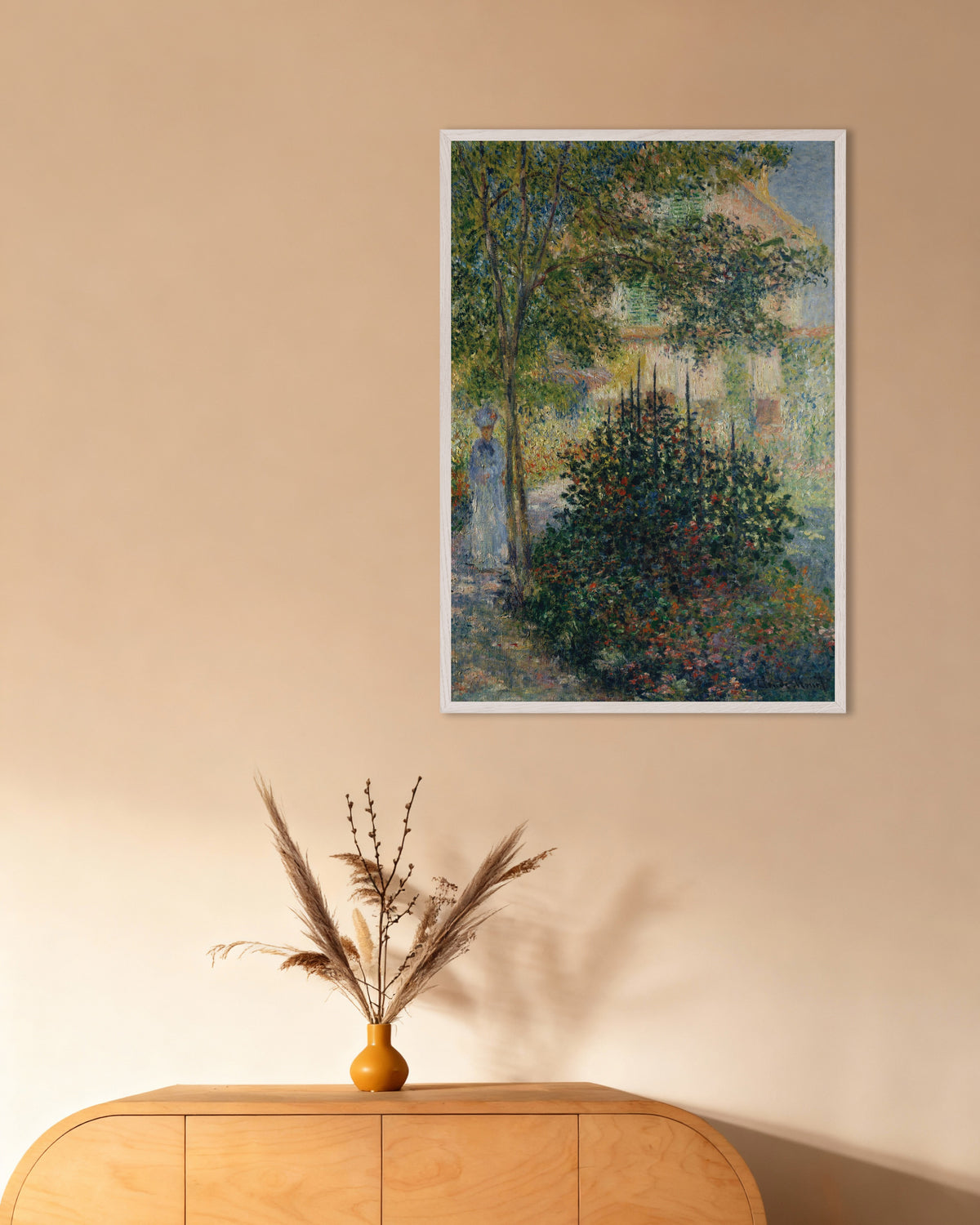 Claude Monet’n Camille Monet Argenteuilin puutarhassa (1876) -juliste valkoisessa puukehyksessä