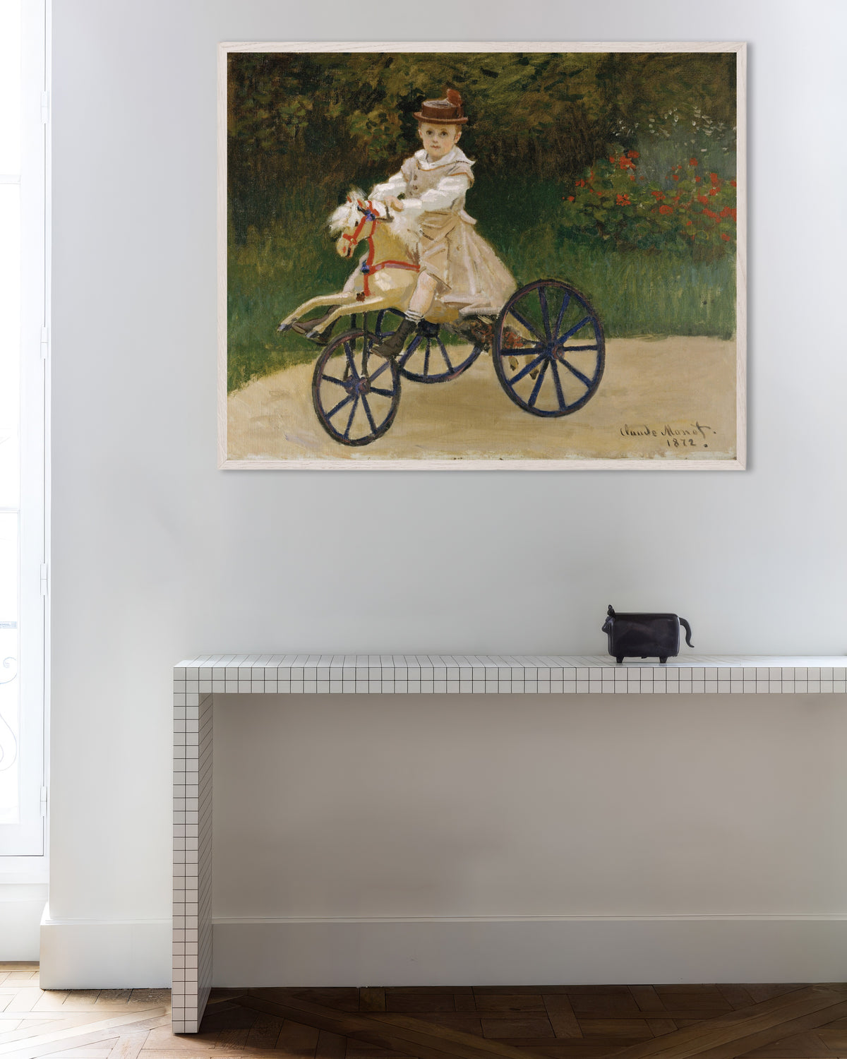 Claude Monet’n Jean Monet keppihevosellaan (1872) -juliste valkoisessa puukehyksessä